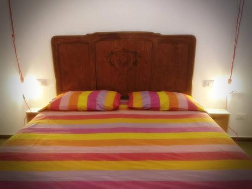 a bed with two colorful striped pillows on it at The Cosy Nest in Pignataro Maggiore