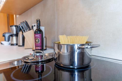 a pot of pasta on a stove with a bottle of wine at Krause: deine Wohlfühloase in Zentrum v. Bielefeld in Bielefeld
