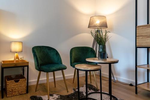 two green chairs and a table with a lamp at Krause: deine Wohlfühloase in Zentrum v. Bielefeld in Bielefeld