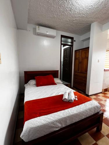 a bedroom with a bed with a red blanket at Hotel Ebenezer in Santo Domingo de los Colorados