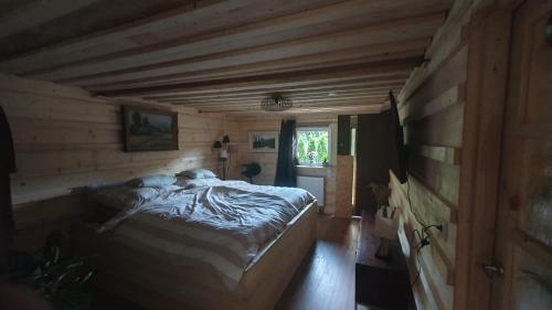 um quarto com uma cama num chalé de madeira em BL Beskydy Lodge em Prostrední Becva