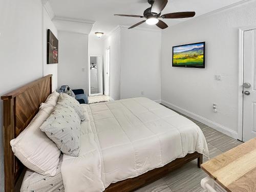 - une chambre blanche avec un lit et un ventilateur de plafond dans l'établissement Central Studio 17, à Miami