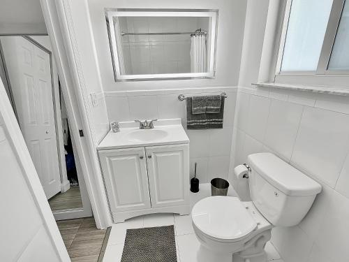 a white bathroom with a toilet and a sink at Central Studio 17 in Miami