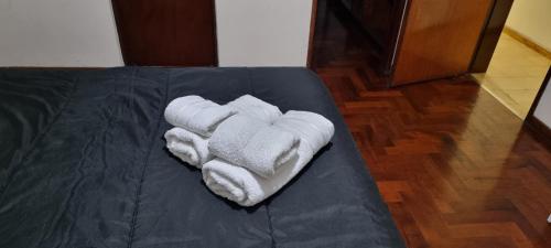 a pile of white towels sitting on a bed at Departamento Mendoza in Mendoza