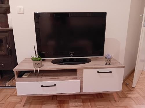 a television on a wooden tv stand with two drawers at Apartments Stela Rosa Ohrid in Ohrid