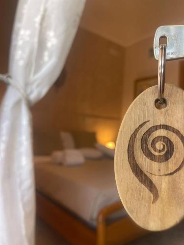 a wooden sign with a spiral on it in a bedroom at Agri Resort Masusa in Aquara