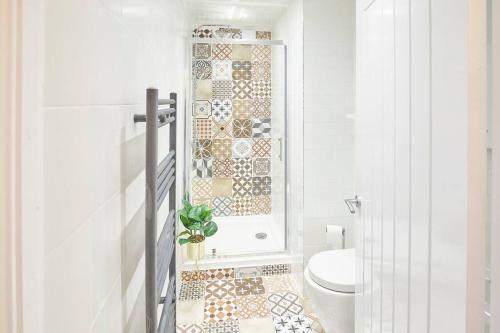 baño con aseo y pared de mosaico en Marshlands, en Redcar