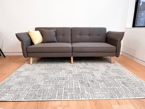 un sofá gris en una sala de estar con alfombra en New Beautiful Modern One Bedroom Apt in Brooklyn at Rem-Casa en Brooklyn