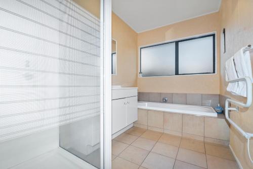 a bathroom with a shower and a bath tub at Bootten's Hut in Rotorua