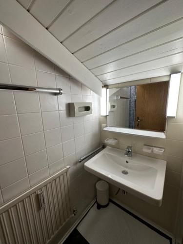 Baño blanco con lavabo y espejo en Urlaub "im Marktl" en Goldegg