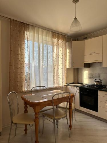 Apartment Ivashchenka 1a في لوتسك: مطبخ مع طاولة وكراسي في مطبخ