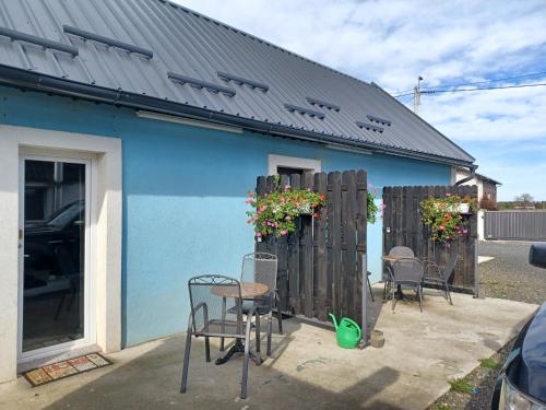 a blue house with chairs and a table in front of it at Aquas AP in Petrijanec