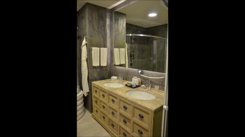 baño con 2 lavabos y espejo grande en Shirvanshah Hotel en Baku