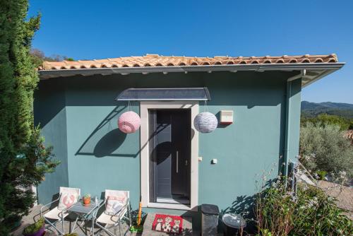 a small blue house with chairs and a table at VILLA FELICETTA PICOLA in Lazaráta