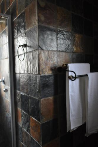 baño con ducha y toallas en la pared en The centaury, en Nelspruit