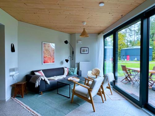 a living room with a couch and a table at Traumhaftes Ferienhaus am See am Lübbesee in Templin in Templin