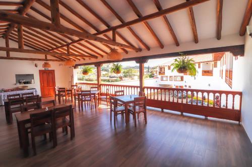 comedor con mesas y sillas de madera en Hotel las Palmas, en Villa de Leyva