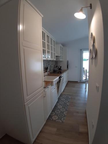 Una cocina con gabinetes blancos y un fregadero. en Villa Diletta, en Àrbatax