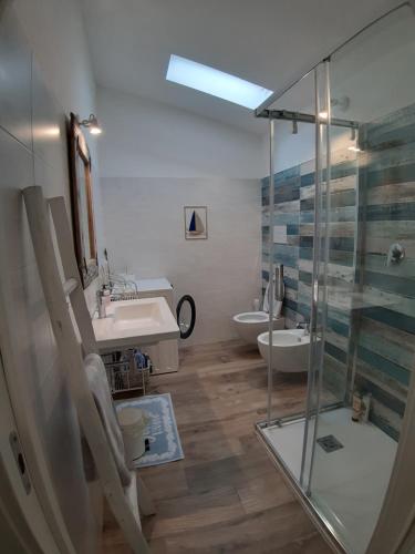 Un baño con ducha de cristal y lavabo. en Villa Diletta, en Àrbatax