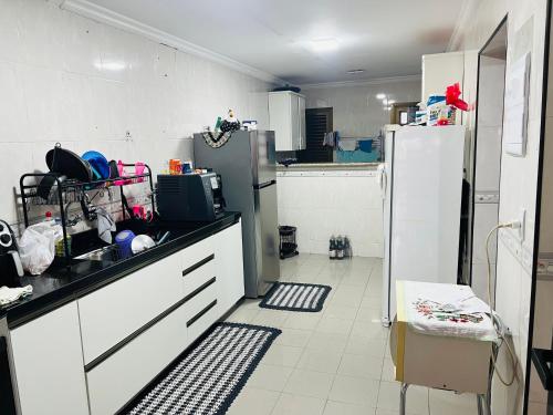 a kitchen with white cabinets and a refrigerator at Casa Guaruja in Guarujá