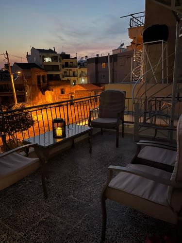 grupa krzeseł i stół na balkonie w obiekcie Retro Apartment Patras w mieście Patras