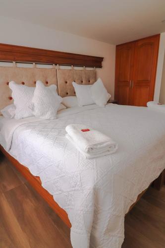 a white bed with a towel on top of it at Hotel las Palmas in Villa de Leyva