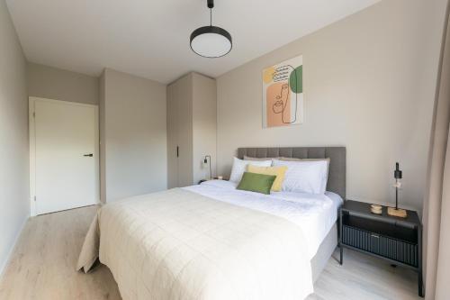 a bedroom with a white bed with a green pillow at Platinum Apartments in Warsaw
