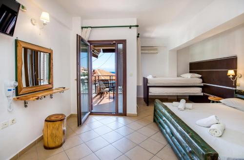 a hotel room with two beds and a balcony at Studios TOUTOULA in Skala Marion