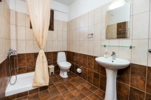 a bathroom with a sink and a toilet and a tub at Studios TOUTOULA in Skala Marion