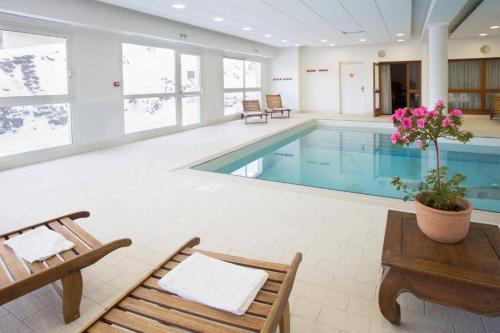 une piscine avec deux chaises et une table dans l'établissement Bel appartement 4 à 6 personnes à 1800, à Puy-Saint-Vincent