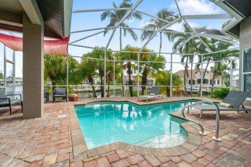 a swimming pool in a building with a large glass ceiling at Manatee Manor in Marco Island