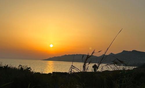 a sunset over the water with mountains in the background at TorrediGaffe Home, una casa nella piazzetta del borgo a due passi dal mare in Torre di Gaffe
