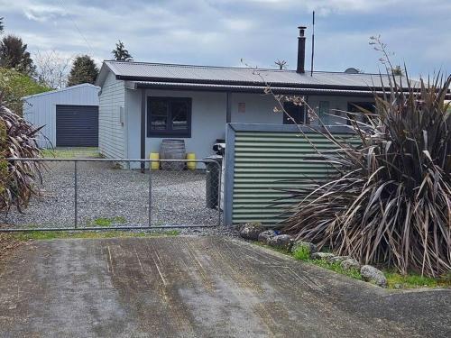a house with a fence in front of it at Marg's on the Corner in Kumara