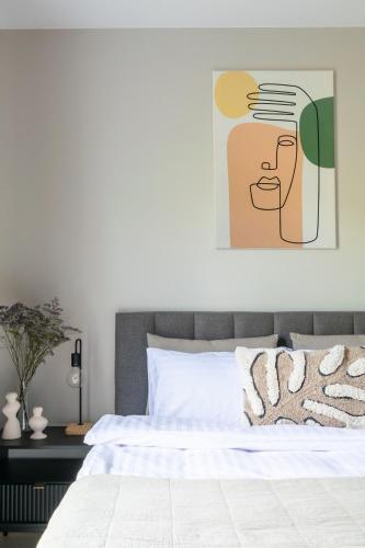 a bedroom with a bed with a painting on the wall at Platinum Apartments in Warsaw