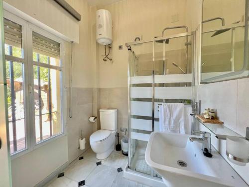 a bathroom with a sink and a toilet and a window at Villa Mijas Playa in Málaga