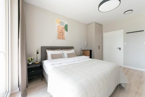 a white bedroom with a large white bed in it at Platinum Apartments in Warsaw