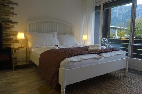 1 dormitorio con cama blanca y ventana grande en Aare Studio 1, en Interlaken