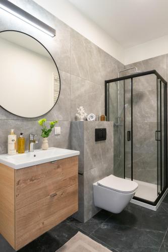 a bathroom with a shower and a toilet and a sink at Platinum Apartments in Warsaw