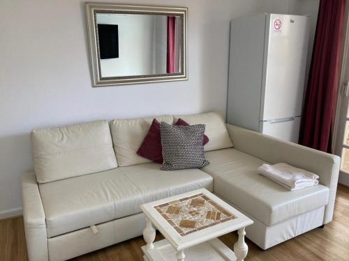 uma sala de estar com um sofá branco e um espelho em Vista Marina em Benalmádena
