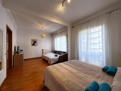 a bedroom with a large bed and a living room at Habitaciones acogedoras in Barcelona