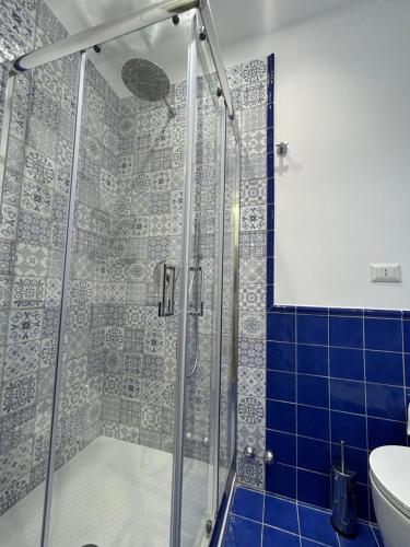 a bathroom with a shower with blue tiles at TorrediGaffe Home, una casa nella piazzetta del borgo a due passi dal mare in Torre di Gaffe
