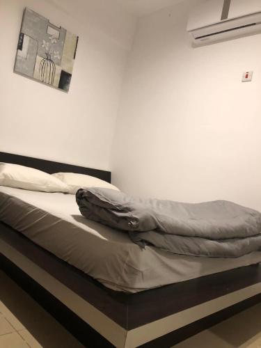 ein unmaskiertes Bett in einem Zimmer mit einem Bild an der Wand in der Unterkunft Rayon Bleu C2 in Flic-en-Flac