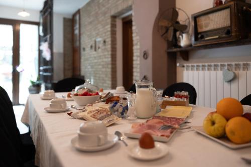 a table with a white table cloth with fruit on it at Locanda Acetaia Malagoli Daniele in Castelfranco Emilia