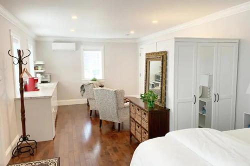 a bedroom with a bed and a desk and a mirror at The Red House Fredericton in Fredericton