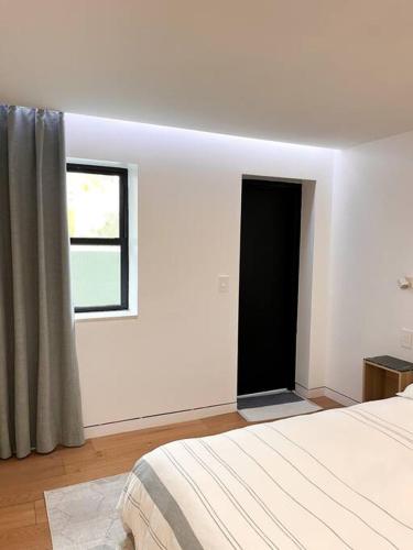 a white room with a bed and a window at New Cozy Modern Minimalist Stay in Brooklyn at Rem-Casa in Brooklyn