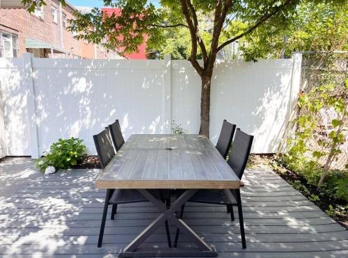a wooden table and two chairs on a patio at New Cozy Modern Minimalist Stay in Brooklyn at Rem-Casa in Brooklyn