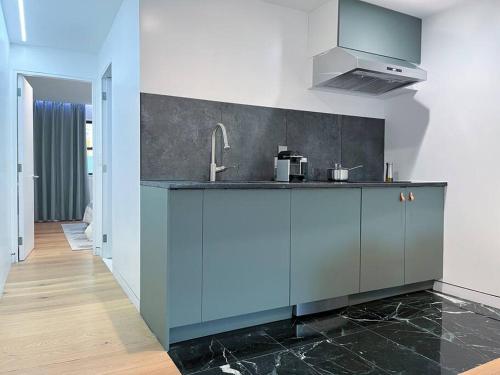 a kitchen with blue cabinets and a sink at New Cozy Modern Minimalist Stay in Brooklyn at Rem-Casa in Brooklyn