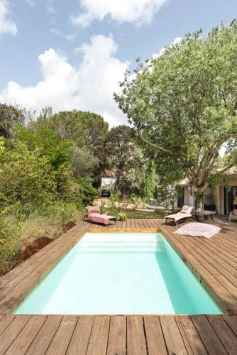 - une piscine bleue sur une terrasse en bois dans l'établissement La Coursive : belle maison de standing avec piscine, à Montpellier