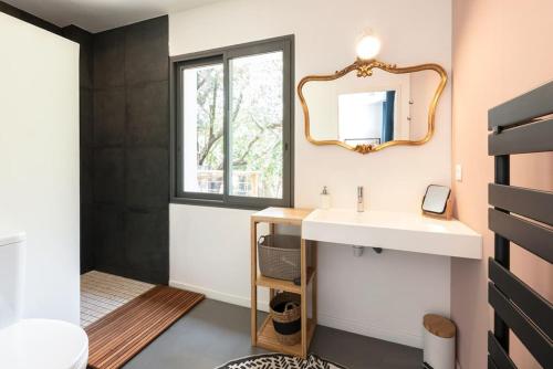 un bagno con lavandino e specchio di La Coursive : belle maison de standing avec piscine a Montpellier