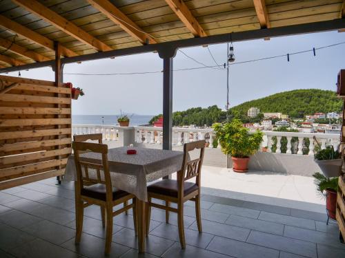 a table and chairs on a balcony with a view of the ocean at Sea Breeze Rooms in Himare